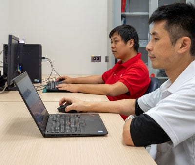 Two UL Solutions employees working on computers